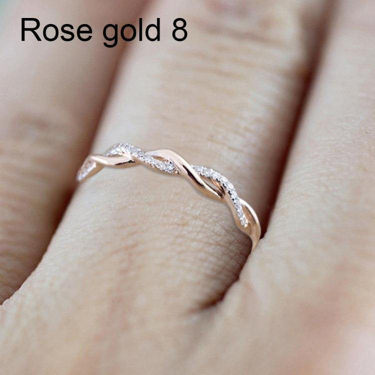 Twist CZ band ring with oval stones, rose-gold tone, close-up on finger