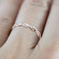 Rose gold twist cubic zirconia ring on finger, curved band with oval stones