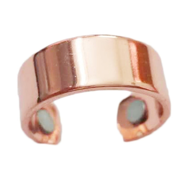 Rose gold open cuff ring close-up with two magnetic disc accents on inner sides