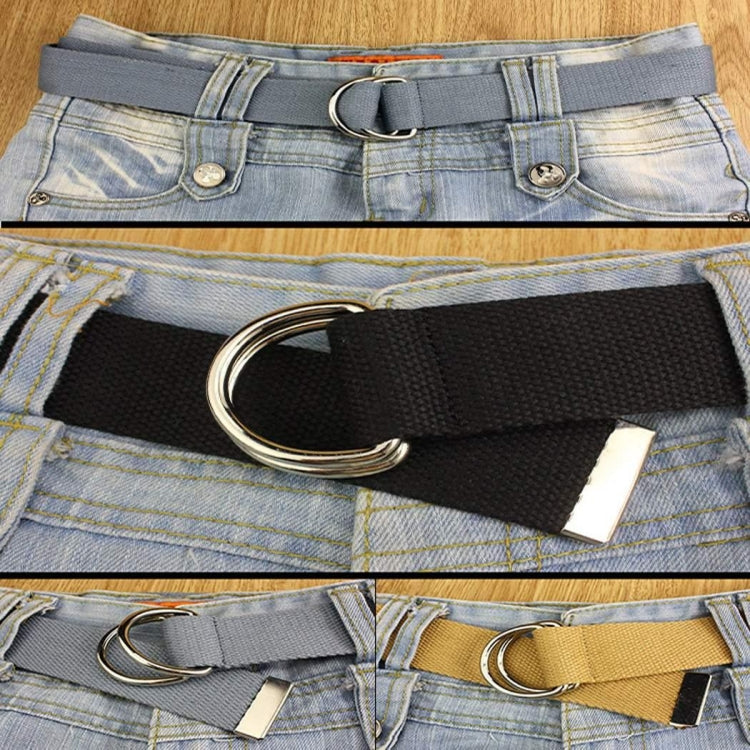 Unisex canvas waist belt with black strap and silver double-ring buckle on denim jeans.