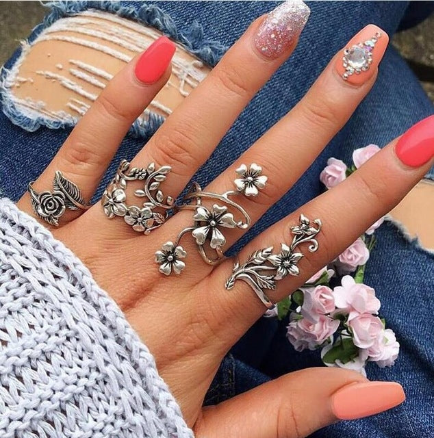 Antique silver rose-flower rings set of four with ornate floral bands worn on fingers