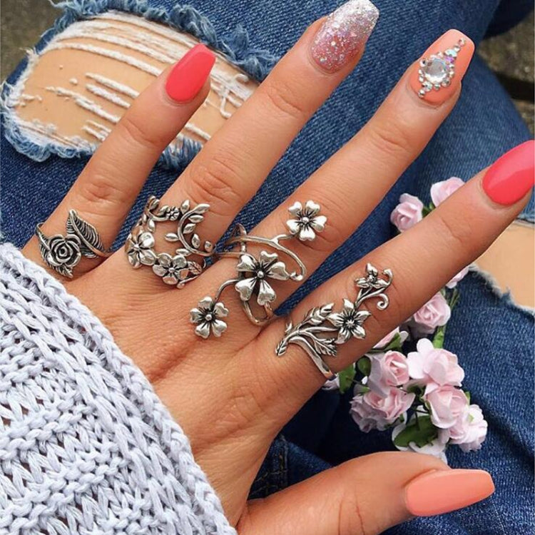 Vintage floral ring set of four with rose and blossom motifs, styled on one hand