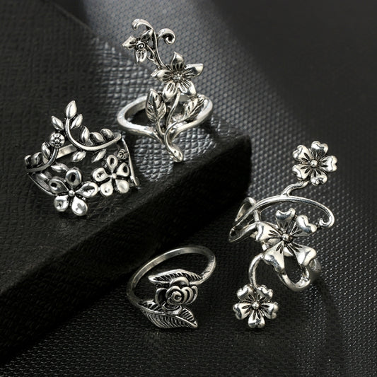 Set of four antique silver floral rings with rose and small flower details