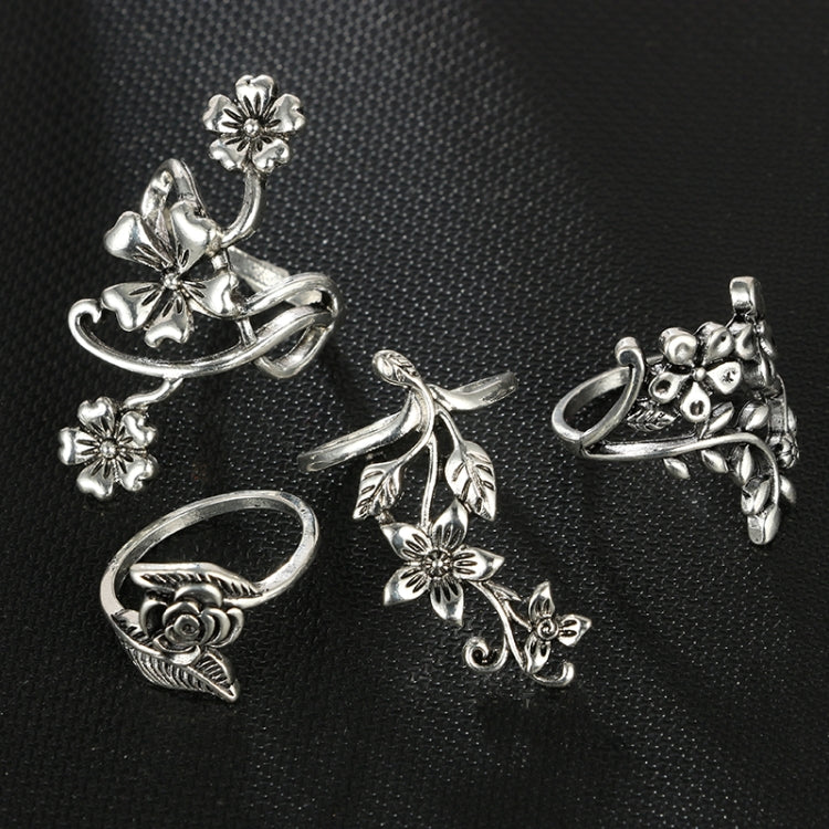 Four antique silver floral rings with rose bud and leaf scroll motifs
