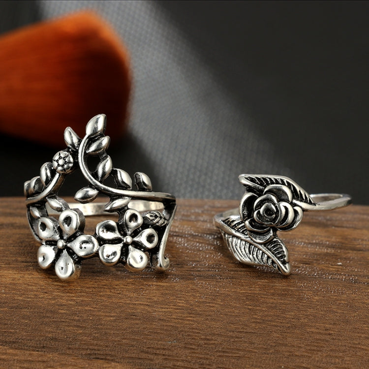 Two antique silver floral rings: rose cluster band and small blossom with leaf scroll