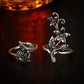 Two antique silver rings with rose and flower accents, including leaf scroll details