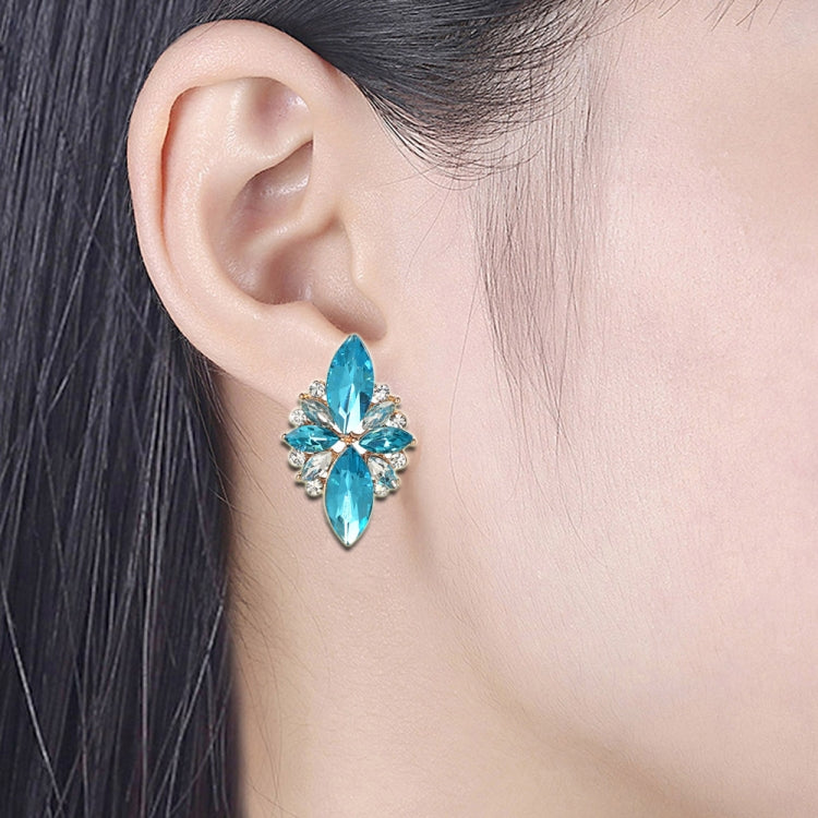 Teal crystal flower earrings on ear, five-petal design with clear rhinestone details