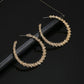 Gold-tone crystal hoop earrings with teardrop hoop profile, stud backs