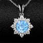 Silver snowflake pendant necklace with bright blue round gemstone and crystal halo.