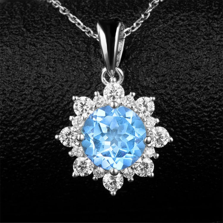 Silver snowflake pendant necklace with bright blue round gemstone and crystal halo.