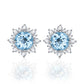Pair of silver stud earrings with bright blue oval gemstone and snowflake crystal halo.