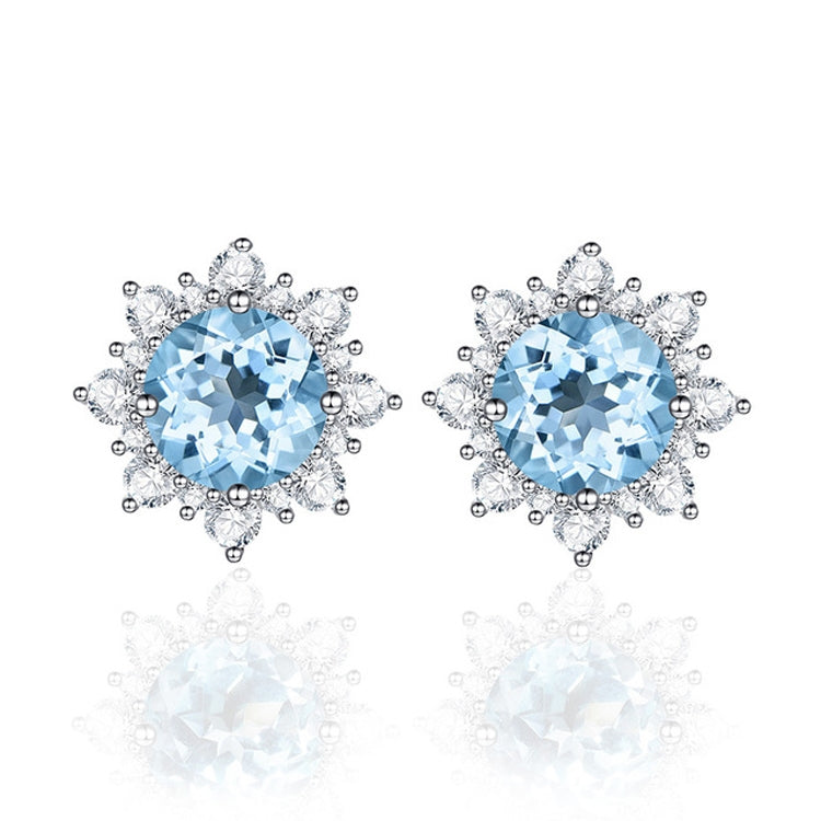 Pair of silver stud earrings with bright blue oval gemstone and snowflake crystal halo.