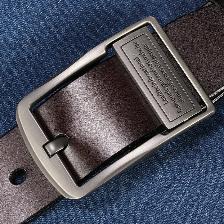 Dark leather pin buckle belt with silver-tone buckle over denim