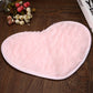 Light pink heart-shaped bath mat with soft shag pile and non-slip edge trim.