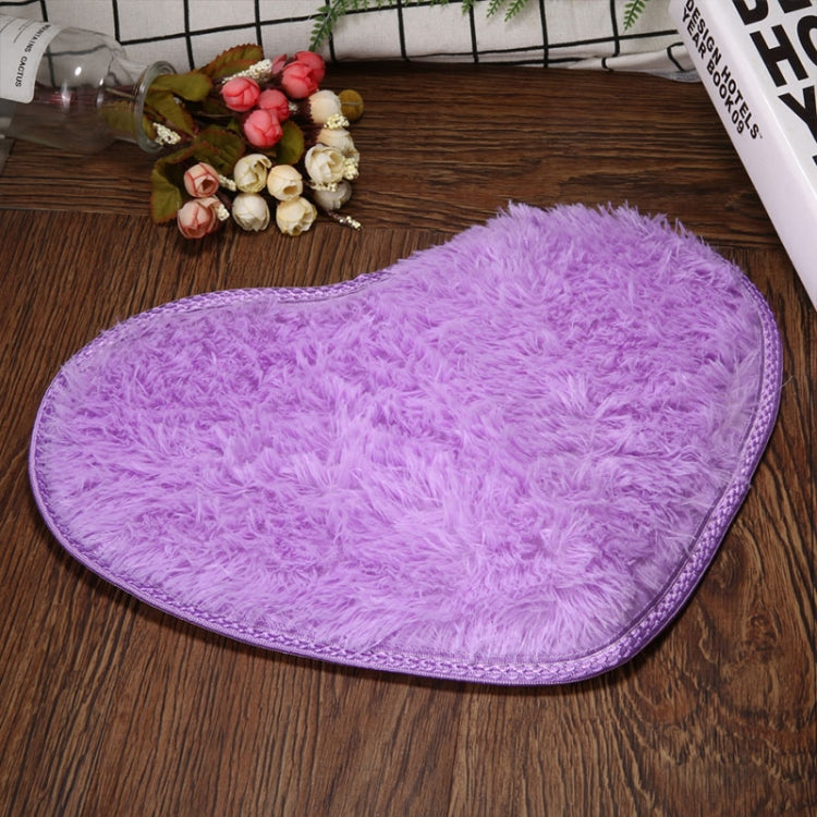 Purple heart-shaped bath mat with fluffy shag texture and non-slip edge binding.
