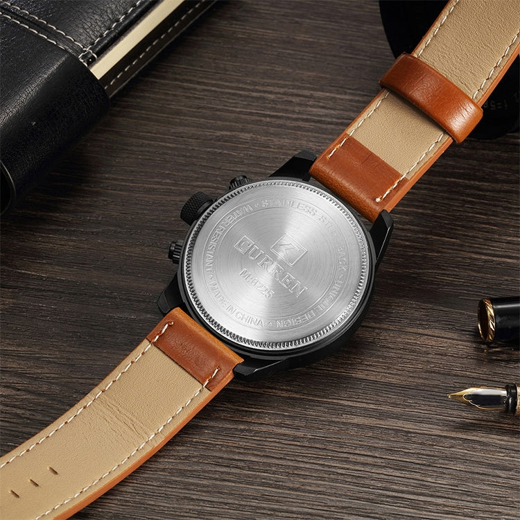 Watch caseback with engraved metal back and two-tone leather straps, tan and dark brown.