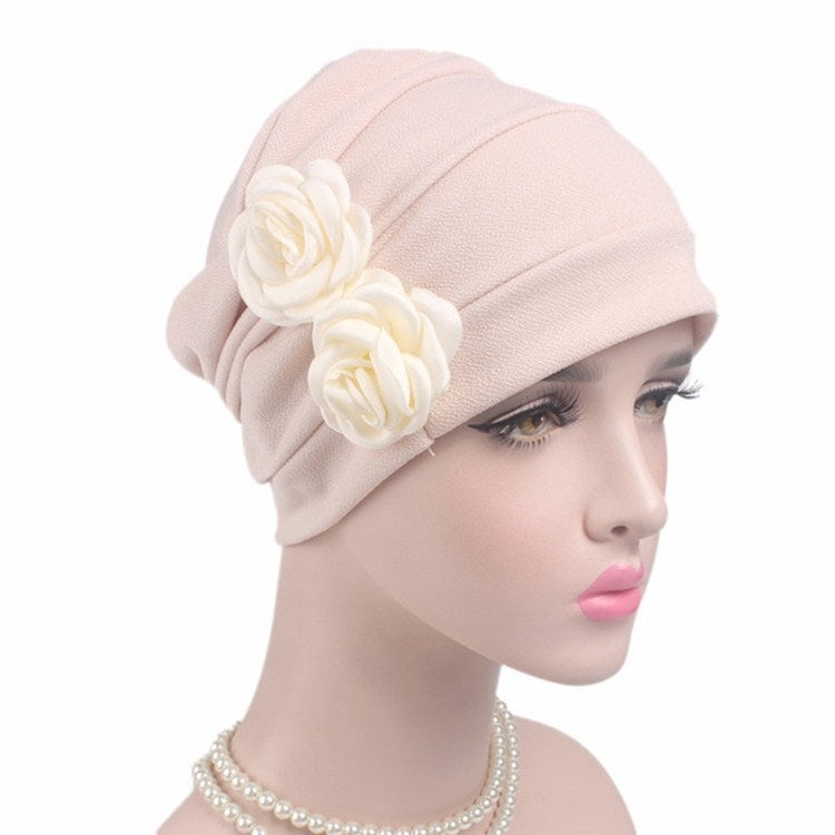Blush pink chemo cap with pleated crown and two fabric rose flowers on side