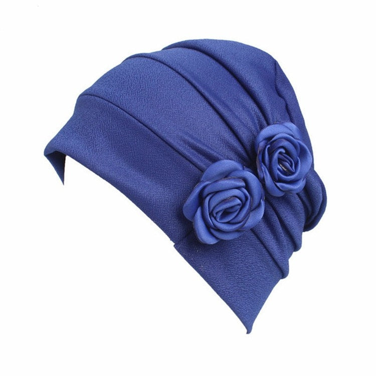 Royal blue flower knit pull-over cap with pleated headband and rosette flower accents