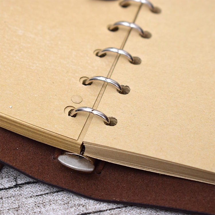 Close-up of metal spiral rings holding kraft paper inside the notebook journal