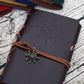 Dark blue pirate spiral notebook journal with embossed compass design and brown leather strap