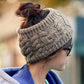 Knit wool earmuff headband in dark beige worn at the side, cable knit texture