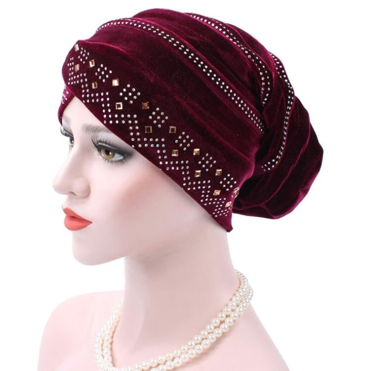 Red wine pleuche turban hat with rhinestone trim and dotted square pattern, side view