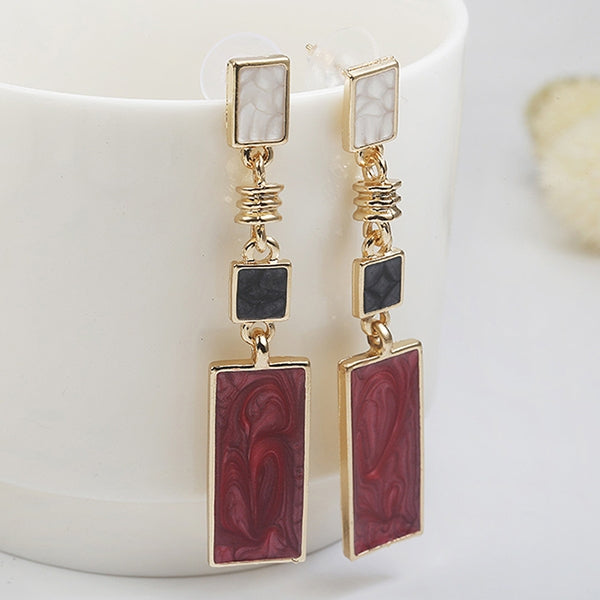 Gold-tone geometric drop earrings with red rectangular dangles, black square, and white top