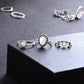 Silver-tone ring set on display with moon, opal-like teardrop, and starburst details