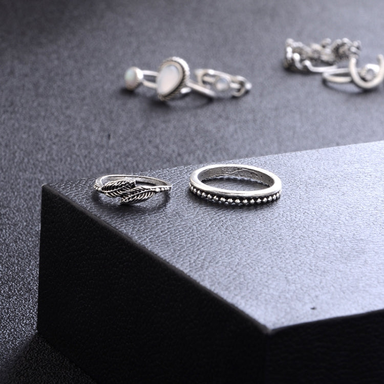 Silver-tone rings on display: braided band, beaded edge band, and leafy design ring
