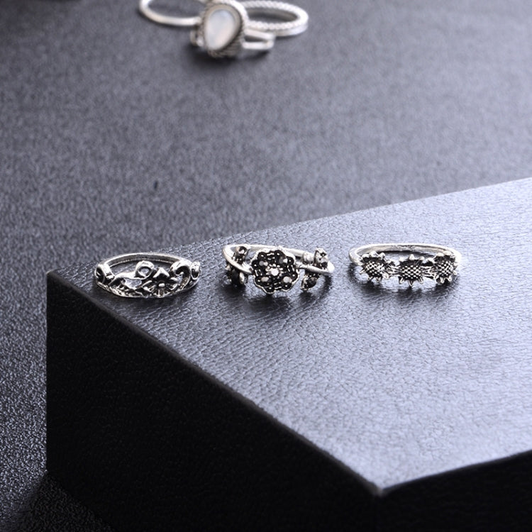 Silver-tone ring set on display featuring dark cluster, textured top, and patterned bands