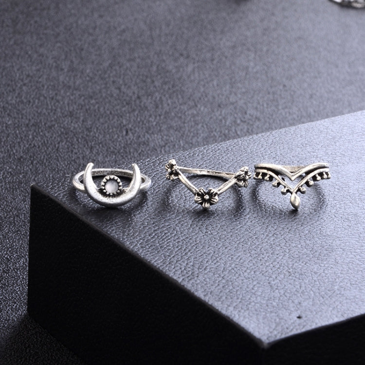 Silver-tone rings on display with sunburst, eye motif, and crescent-like cutout design