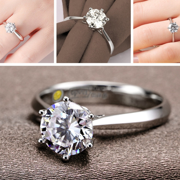 Silver-tone ring with round CZ center stone and slim band, close-up on hand