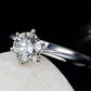 Silver-tone ring with large round CZ solitaire and six small ball prongs, glossy finish