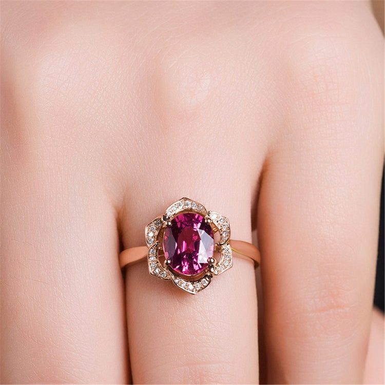 Rose gold flower-shaped ring with red tourmaline center and clear stones