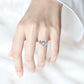 Silver wedding ring on hand with three-stone center and small side stones