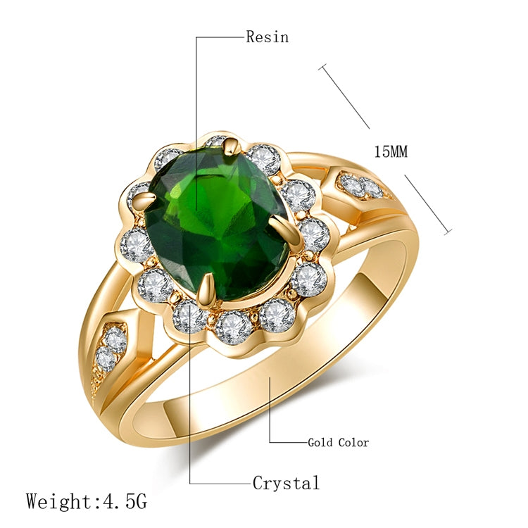 Gold ring with oval green center and round clear stones, halo setting