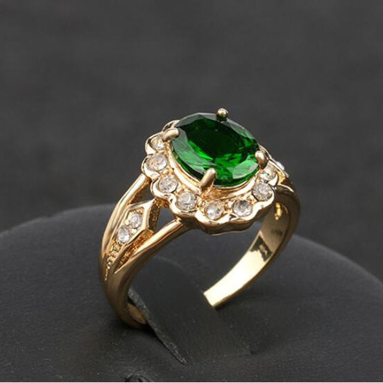 Gold vintage ring with oval green center gemstone and round clear halo stones