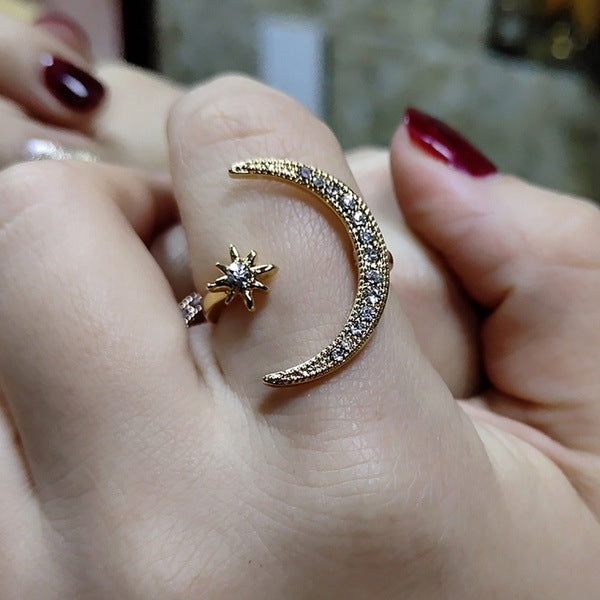 Silver-tone crescent moon crystal ring with star detail and glitter band on finger