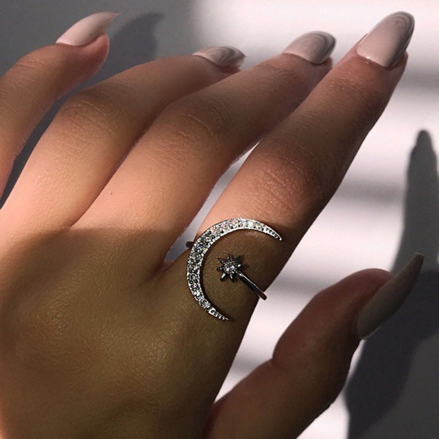 Crescent moon crystal ring with star top detail, silver-tone sparkle band on finger