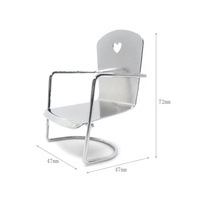 Miniature metal dollhouse chair with heart cutout backrest and open seat frame