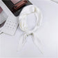 White pleated square silk scarf, looped and tied with vertical pinstripe long ends