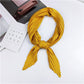Golden yellow pleated square silk scarf, looped and tied with long striped ends
