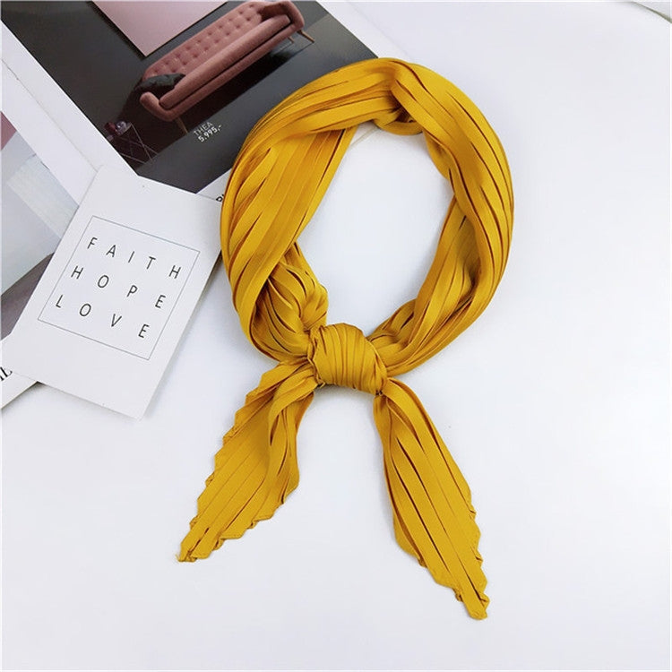 Golden yellow pleated square silk scarf, looped and tied with long striped ends