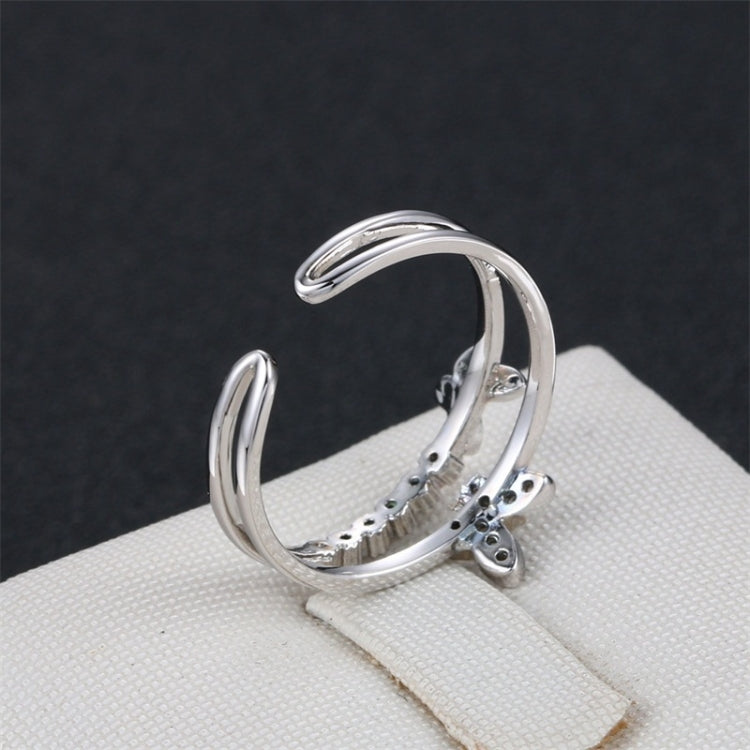 Platinum butterfly diamond opening ring, side view of curved stacked bands