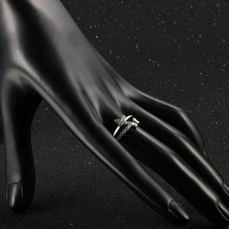 Platinum butterfly diamond ring on hand, small butterfly motif on slim opening band