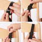 Black stroller harness buckle being fastened with adjustable strap ends.