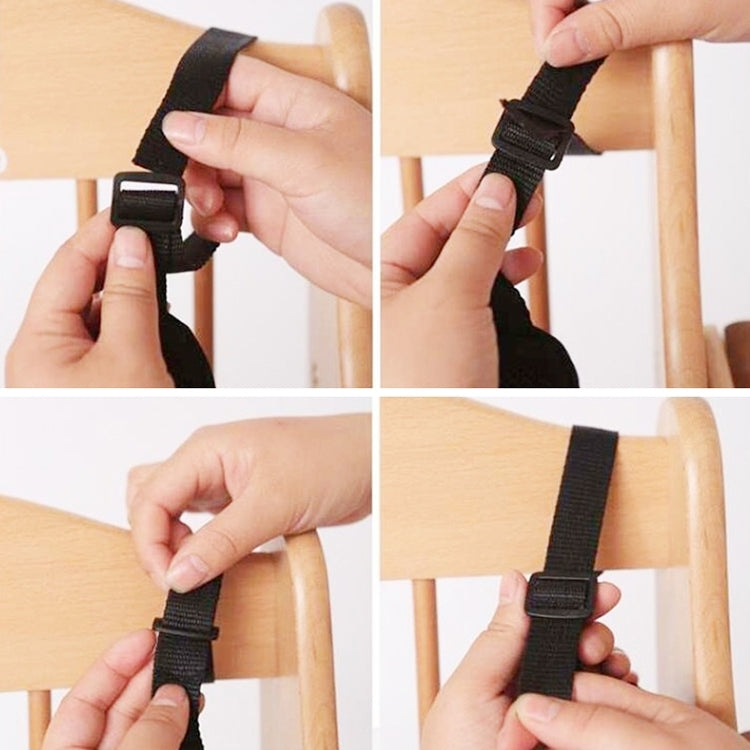 Black stroller harness buckle being fastened with adjustable strap ends.