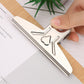 Close-up of hand attaching metal butterfly clip to wooden clipboard