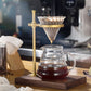 Brass hand coffee filter holder with glass carafe, filter draining into carafe