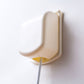 Child switch protective cover installed on outlet, cream with yellow safety tab